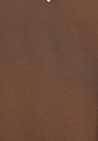 Tissu tissé brun avec une texture subtile, présentant une ouverture en v et un petit accent blanc au niveau du col.