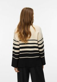 Maglione di maglia oversize color crema con strisce nere orizzontali, dotato di orlo a coste e maniche larghe, texture liscia e vestibilità morbida.