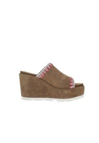 Sandalias de cuña de ante marrón con diseño de punta descubierta, que presentan un detalle trenzado en rosa y blanco a lo largo del borde y una suela blanca con relieve.