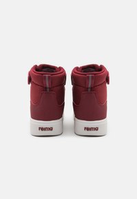 Bottes pour enfants bordeaux avec un collier rembourré, des sangles réglables et des semelles en caoutchouc blanches. Talon renforcé et tige textile lisse.