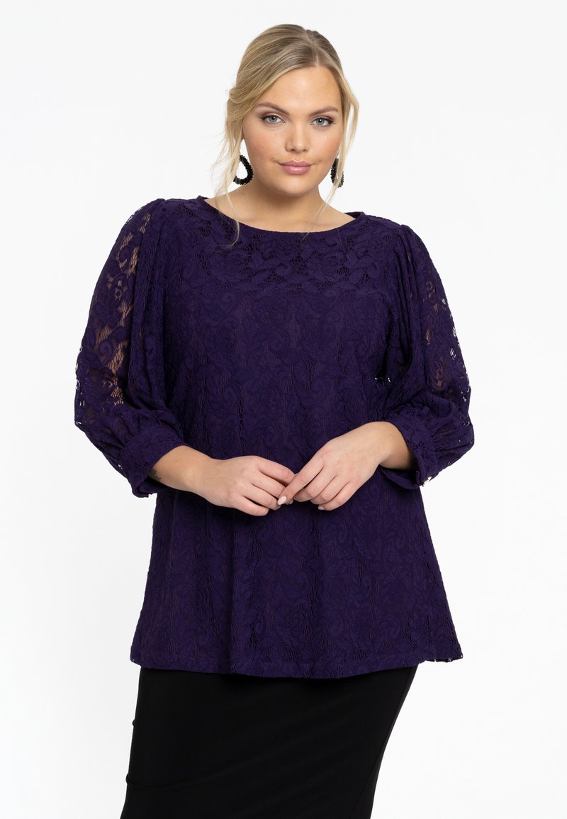 Paarse kantblouse met driekwart pofmouwen, ontworpen met getextureerde bloemenpatronen, gecombineerd met een zwarte rok.