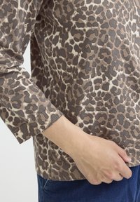 Braun gefleckter Pullover mit Rippenbündchen und Saum. Weiche Textur, lässiges Design. Hat eine lockere Passform, was an den Ärmeln und der Taille zu sehen ist.