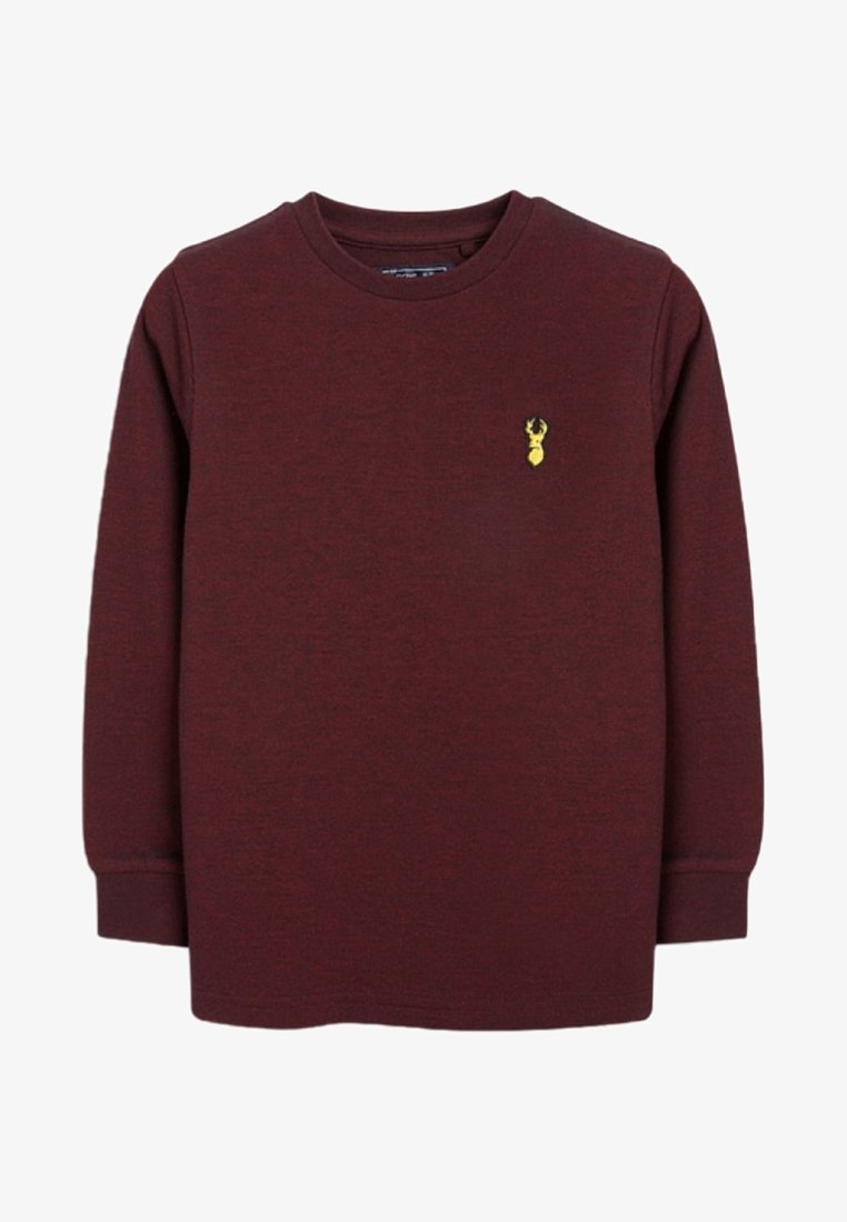 Chemise à manches longues col rond bordeaux avec poignets côtelés et petit emblème jaune en forme de tête de cerf sur le côté gauche de la poitrine.