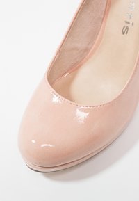 Escarpin rond pour femme de couleur rose clair brillante avec une semelle plate-forme basse, présenté en vue en angle depuis le dessus.