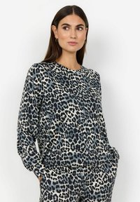 T-shirt à manches longues en tissu doux avec un imprim�é léopard noir, gris et beige. Encolure arrondie et coupe décontractée avec poches latérales.