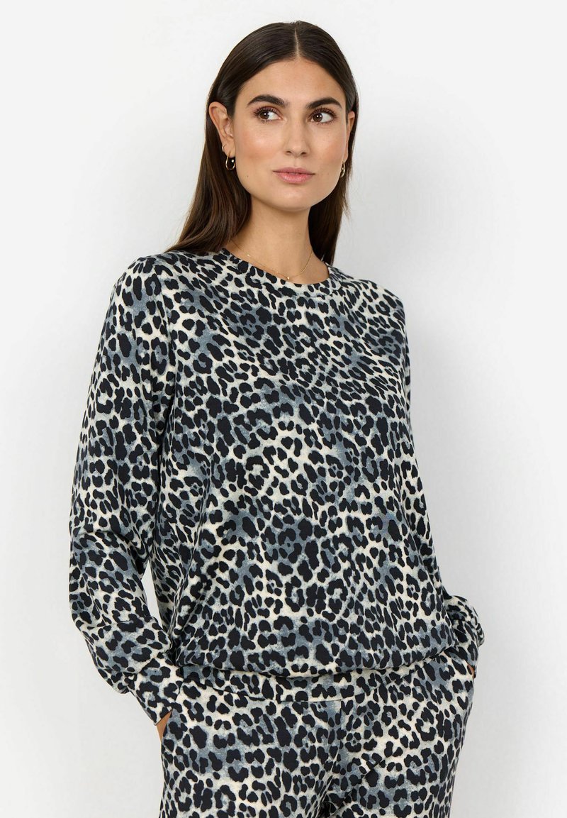 T-shirt à manches longues en tissu doux avec un imprimé léopard noir, gris et beige. Encolure arrondie et coupe décontractée avec poches latérales.