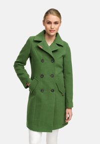 Manteau en laine mélangée vert, avec un design à double boutonnage, de grands boutons noirs, des poches latérales et un col cranté. Fini texturé.