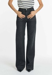 Brede donkere denim jeans met een hoge taille, voorzakken en een klassieke knoopsluiting. De stof heeft een gladde, licht gestructureerde afwerking.