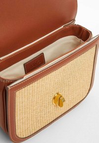 Ruskea nahkainen käsilaukku, jossa on kudottu oljen etuosa, varustettuna kultaisella kiinnityksellä. Sisäpuolella on beige kangas ja sisällä etiketti.