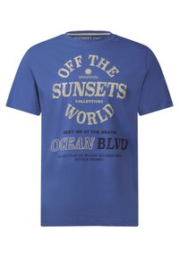 Niebieska koszulka z krótkim rękawem, materiał bawełniany, z nadrukowanym tekstem w kolorze kremowym i czarnym, w tym "OFF THE SUNSETS" i "OCEAN BLVD."