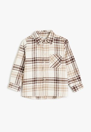Chemise boutonnée à carreaux en crème, beige et marron. Présente un col, des manches longues et une poche poitrine avec un motif à carreaux en diagonale.