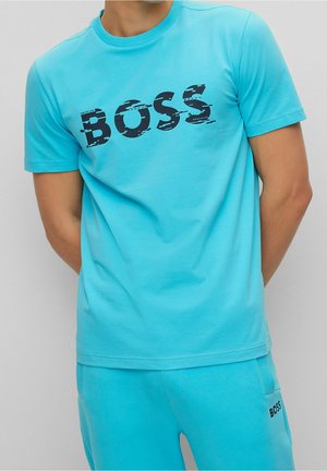 Türkisfarbenes Baumwoll-T-Shirt mit einem abgenutzten schwarzen "BOSS"-Logo auf der Brust. Kurze Ärmel und Rundhalsausschnitt.