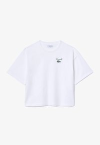 T-shirt courte blanche en coton avec des manches courtes, arborant un logo crocodile brodé en vert et le nom de la marque sur la poitrine.