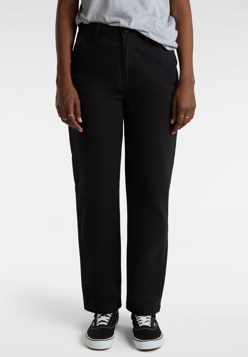 Zwarte broek met een rechte pijp, gemaakt van katoen, met voorzakken en opgerolde boorden, gecombineerd met zwarte sneakers.