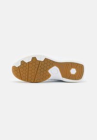 Suola della scarpa con un motivo a nido d'ape, gomma bianca con una sezione in gomma marrone; presenta un design con tagli esagonali e pentagonali.