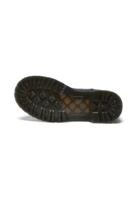 Suela de bota de goma negra con un patrón de banda de rodadura profundo, que presenta una superficie texturizada y surcos estructurados para agarre y tracción.