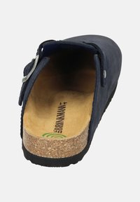 Zoccolo in pelle blu navy con soletta in sughero imbottita e suola in gomma nera. Presenta una fibbia metallica argentata e una tomaia testurizzata.