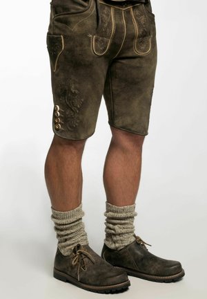 Brown leather shorts feature detailed embroidery and side pockets. Paired with grey knitted socks and dark shoes with laces.