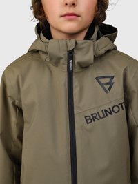 Bambino che indossa una giacca verde oliva chiusa fino al collo con cappuccio, con logo BRUNOTTI nero sul petto e sul cursore della zip.