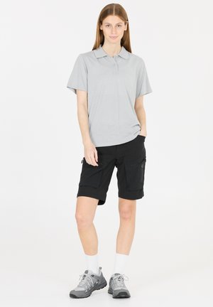 Ljusgrå kortärmad polotröja i kombination med svarta cargoshorts med flera fickor, samt grå vandringsskor med snörning.