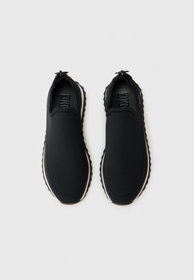 Baskets noires à enfiler en matériau lisse et flexible avec une semelle texturée. Présentent un design minimaliste et des détails de marque subtils.