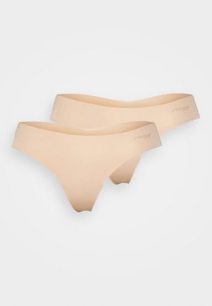 Nude sømløse tanga med et glatt, elastisk stoff. Har et lavt liv og minimal dekning, merket med 'loggi'.