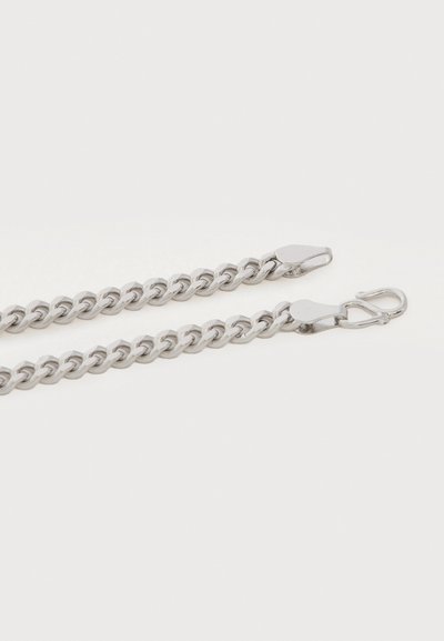 Dva stříbrné kovové řetězy s proplétanými články, každý končící karabinkou a háčkovou sponou, na bílém pozadí.