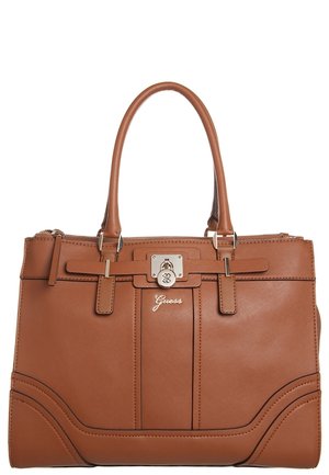 Brown leather Guess handbag with double handles, front lock clasp, and subtle stitched detailing on a white background.
