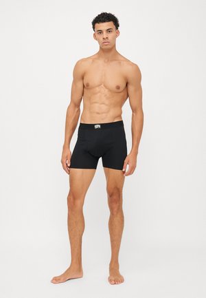 Schwarze Boxershorts mit enganliegendem Schnitt. Hergestellt aus einem glatten, dehnbaren Material. Verfügt über einen elastischen Bund mit Logo. Minimalistisches Design.