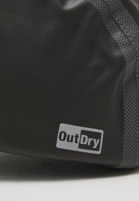 Black and gray waterproof bag featuring a textured surface and logo label. The design includes a smooth finish and geometric patterned accents.