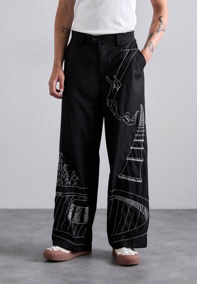 Black wide-leg pants featuring white embroidered designs depicting figures, trees, and abstract shapes. Smooth fabric with a relaxed fit.