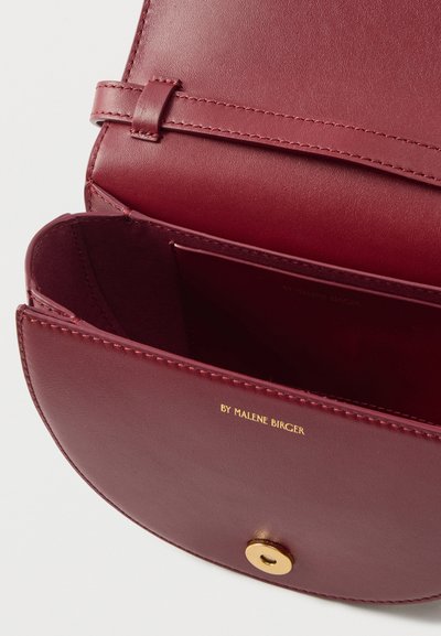 Τσάντα από δέρμα μπορντό με λεία υφή, με χρυσό κούμπωμα τύπου snap και ανάγλυφο λογότυπο της μάρκας εσωτερικά. Ανοιχτό διαμέρισμα για αποθήκευση.