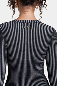 Sort og grå stribet top med ribbet tekstur, der har et lille broderet logo nær halsudskæringen og lange ærmer.