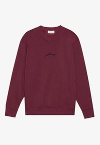 Sweatshirt bordeaux à col rond en coton avec des manches longues, arborant un petit logo noir brodé sur la poitrine. Texture douce.