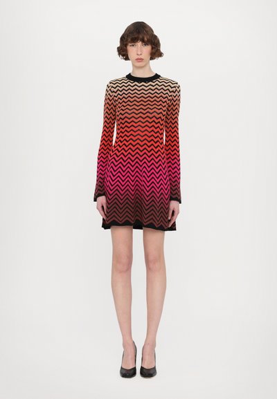 Vestido de manga longa com um padrão em zigzag em tons degradê de vermelho, laranja e preto, com um decote redondo e um design ajustado.