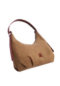 Bolso hobo de ante marrón con textura suave, forma curva y una correa de cuero marrón contrastante. Presenta un logo en relieve en el frente.