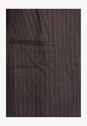 Tessuto scuro a righe con sottili righe bianche; presenta una tasca a filetto a sinistra. Il materiale appare liscio con una leggera texture.