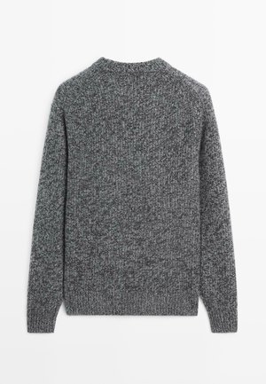 Grå strikket sweater med et tekstureret mønster, rund hals og lange ærmer. Stoffet indeholder en blanding af mørke og lyse grå nuancer.