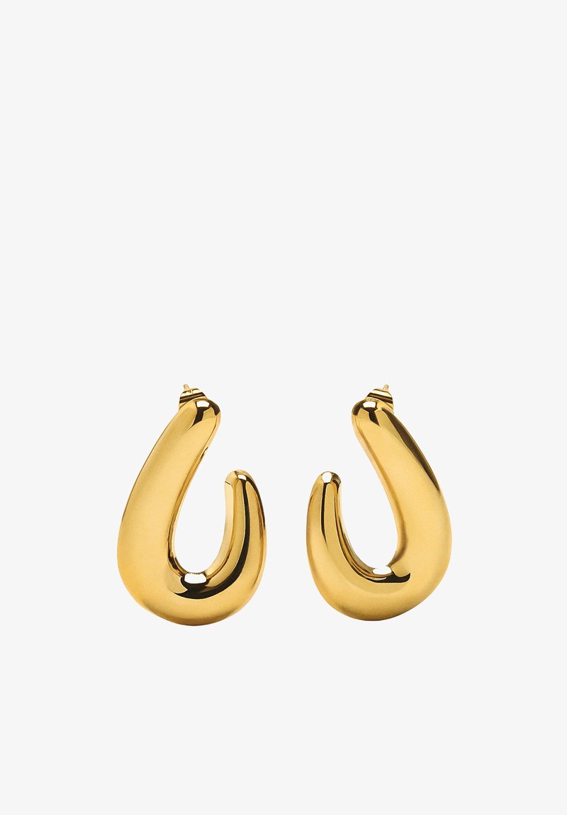 Złote kolczyki w kształcie obręczy o gładkim, zakrzywionym wzorze. Posiadają błyszczące wykończenie i zwężający się kształt, podkreślający ich unikalną sylwetkę.