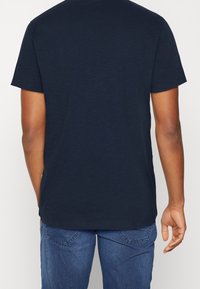 Mörkblå kortärmad t-shirt i mjuk bomullsblandning, med en avspänd passform och en enkel rund halsringning.