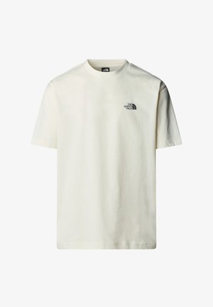 Bavlněné tričko v krémové barvě s krátkým rukávem, kulatým výstřihem a malým černým potiskem loga na levém hrudníku. Hladká textura.