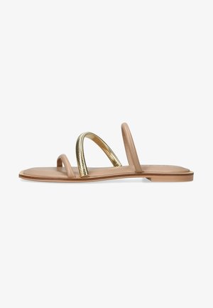 Sandalias planas nude con dos tiras estrechas y un acento en espiral metálico dorado. Presentan una textura suave y un diseño sencillo y abierto.