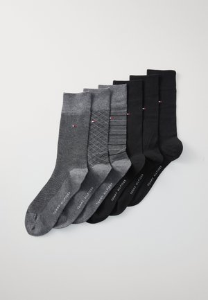 Sieben Paar Socken in Grau und Schwarz, mit verschiedenen Mustern, darunter gerippte und diamantförmige Designs, sowie mit markenbezogenen Akzenten in Rot und Weiß.
