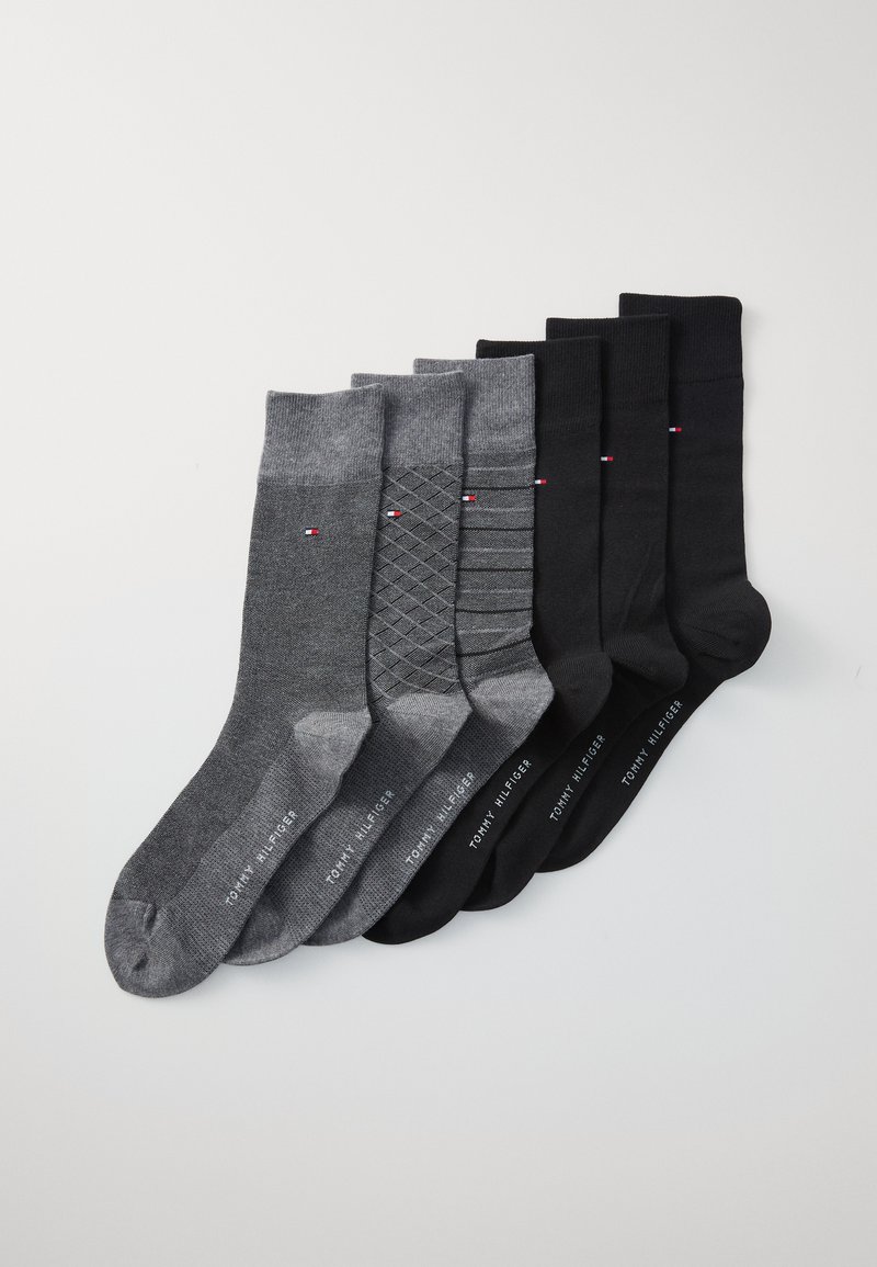 Sieben Paar Socken in Grau und Schwarz, mit verschiedenen Mustern, darunter gerippte und diamantförmige Designs, sowie mit markenbezogenen Akzenten in Rot und Weiß.