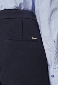 Marinblå byxor med strukturerad tyg, slim fit, accentuerade med en guld "BOSS"-logotyp på bakfickan. Klassisk design, skräddarsydd för en modern look.