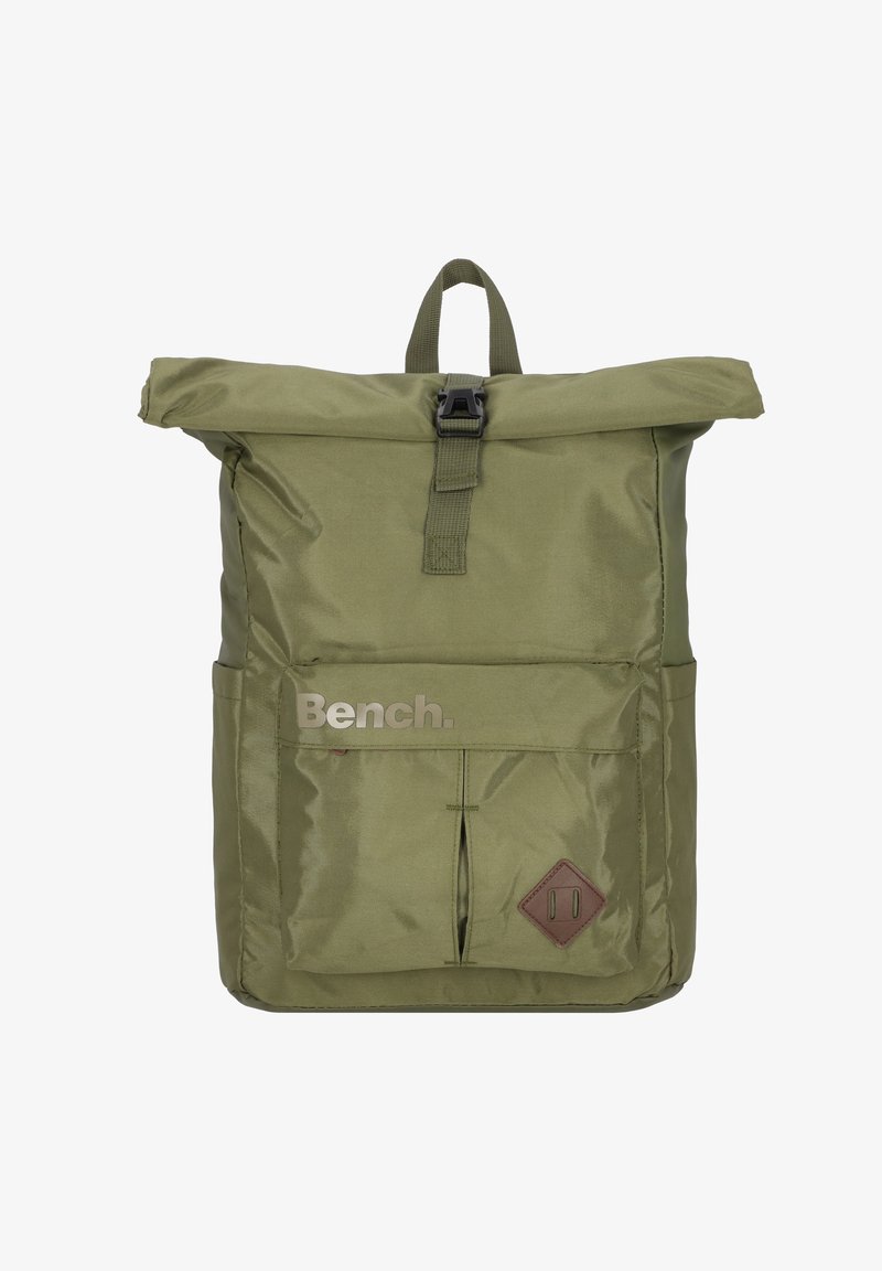 Sac à dos en nylon vert avec un système de fermeture enroulable, une poche avant et un accent en cuir marron en forme de diamant. Présente le texte "Bench." à l'avant.