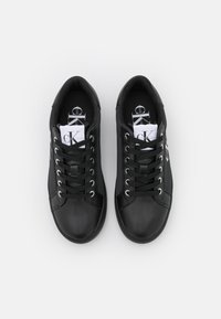 Czarne skórzane sneakersy o gładkiej teksturze, okrągłym nosku, metalowymi oczkami i płaskimi sznurówkami. Logo marki widoczne z boku i na wkładce.