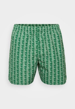 Șorturi de baie verzi cu un model geometric alb pe întreaga suprafață, având un brâu elastic pentru confort și un material ușor, texturat.