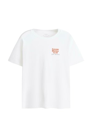 T-shirt bianca a maniche corte con piccolo testo arancione e nero sul petto a sinistra con la scritta "SUNDAY BRUNCH CLUB (STILL BRUNCHING)".