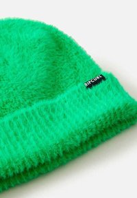 Lys grøn hue lavet af fuzzy materiale. Har en ribbet kant og et lille sort logo mærke med "RIPCURL" på siden.